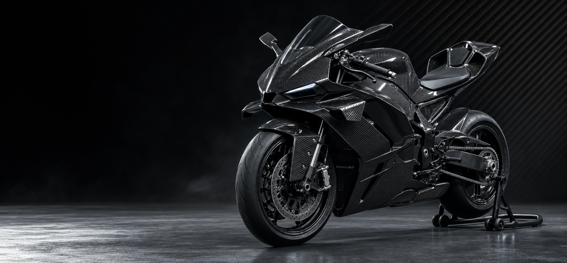 Black carbon fiber sport motorcycle in a silver and graphite studio
